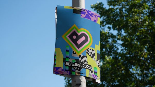 A lampost banner with the Bradford 2025 logo in the centre