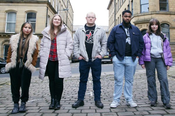 A group of young people stand in a line in a Bradford street