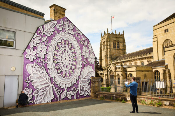 Mural by NeSpoon, with Bradford Cathedral in the background.