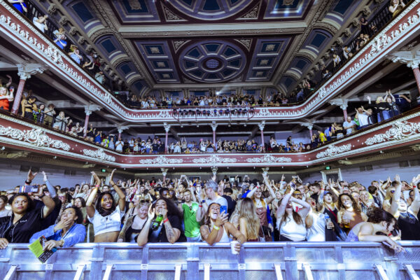 A shot from the stage of St. George's hall showing a packed auditorium, full of cheering people.