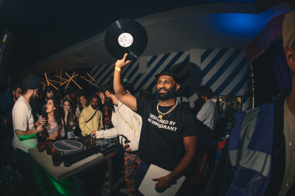 Male holding a vinyl in the air looking like he's having a good time.