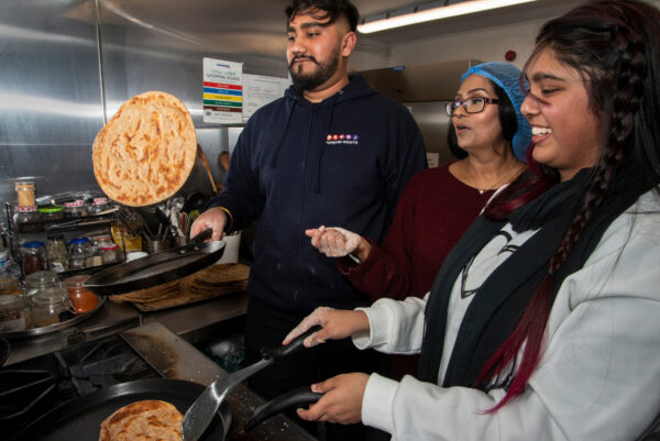 Youngsters learning traditional Asian recipes from their older 'Aunties' from the Womenzone community centre in Bradford.