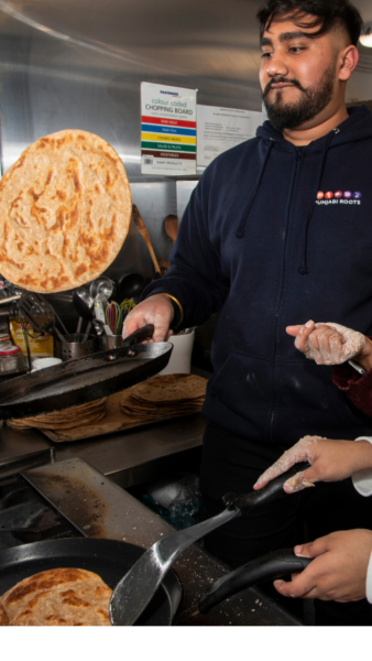 Youngsters learning traditional Asian recipes from their older 'Aunties' from the Womenzone community centre in Bradford.