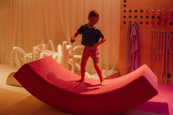 Young person balancing on a balancing arc.