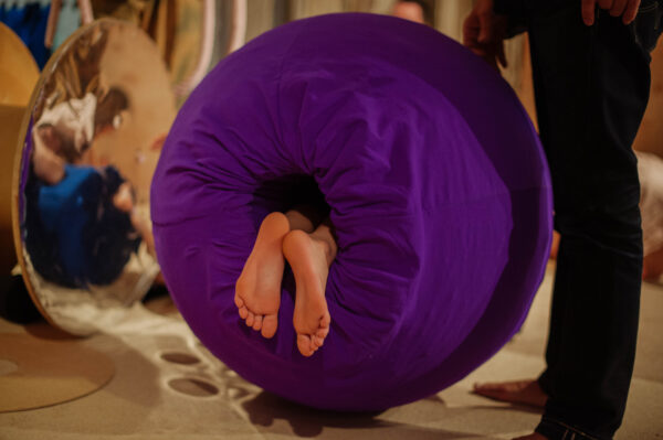 Feet poking out a purple cylinder.