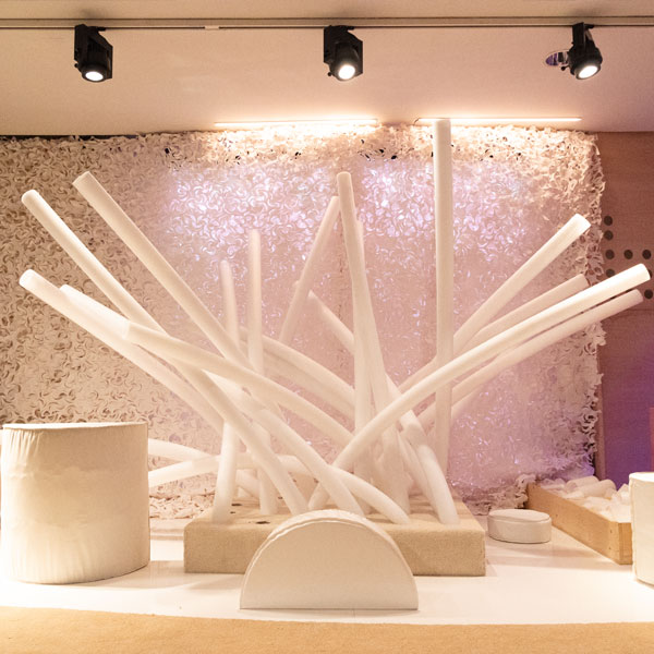 White foam batons are lit up alongside geometric white shapes