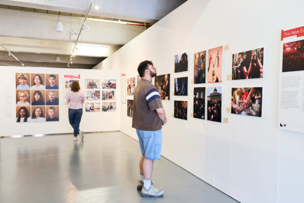 People study the photos lining the gallery wall.