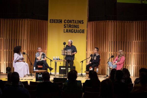 A shot of four people performing at Contains Strong Language