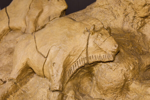 A fake carving of a bison in pale yellow stone.
