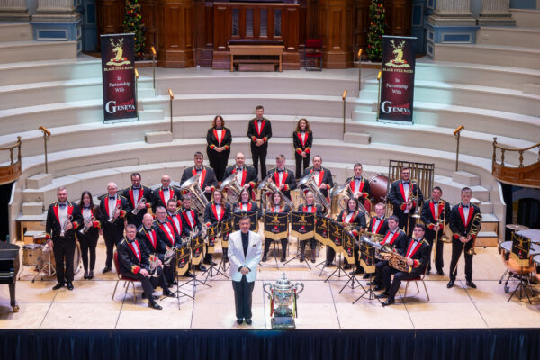 A full brass band dressed smartly in red and black uniforms.