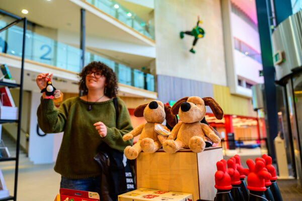 A woman poses in the foyer of the National Science and Media Museum with Gromit plushy toys in the foreground