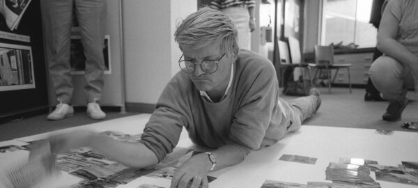 Artist David Hockney working on the floor of a studio.