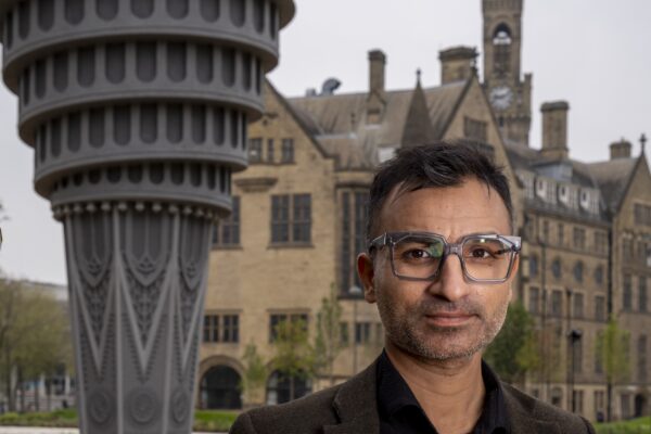 Artist Saad Qureshi stands in front of Tower of Now, a large public artwork
