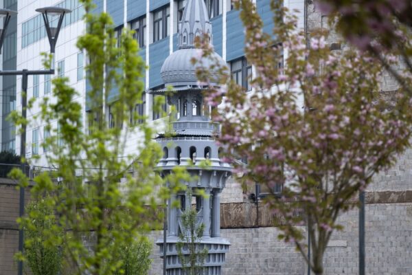 The Tower of Now, a large public artwork, seen between two trees