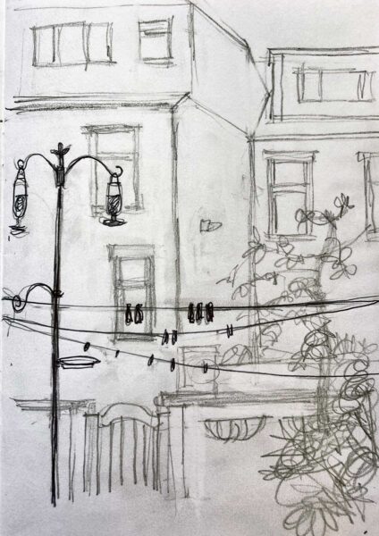 Pencil drawing of the back of houses and a street light.