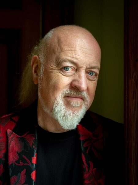 A head shot of Bill Bailey in a red jacket.