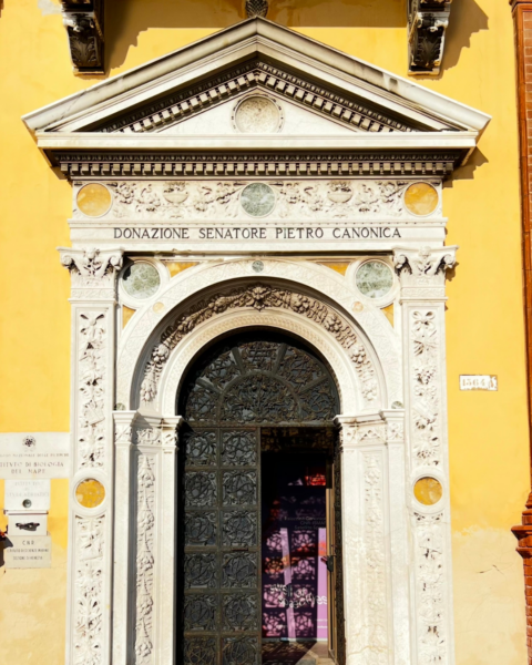 A yellow-painted building with a white, ornate entrance in Venice, Italy.