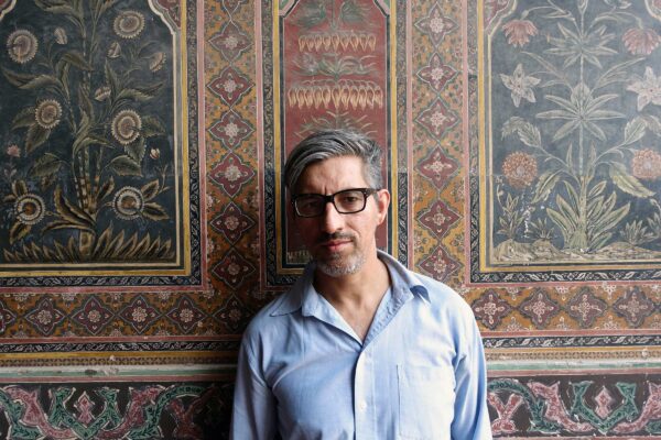 Headshot of artist Wajid Yaseen against a patterned background.