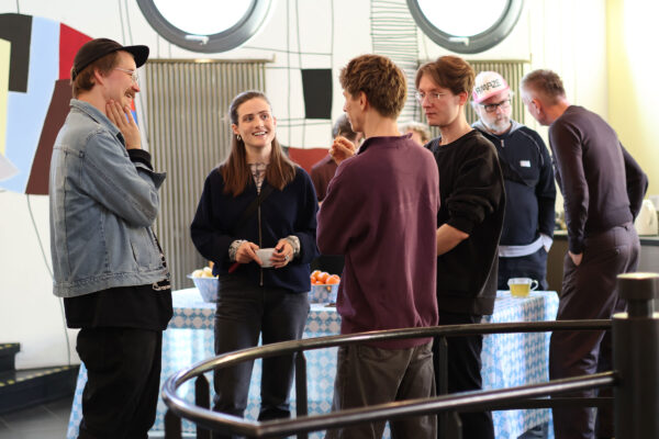 A group of people chat and enjoy food.