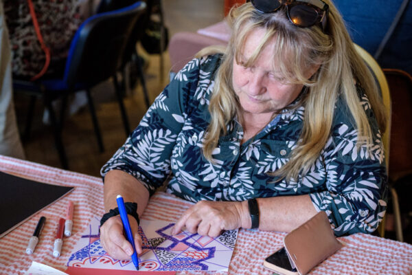 A lady sat in a workshop drawing and creating art