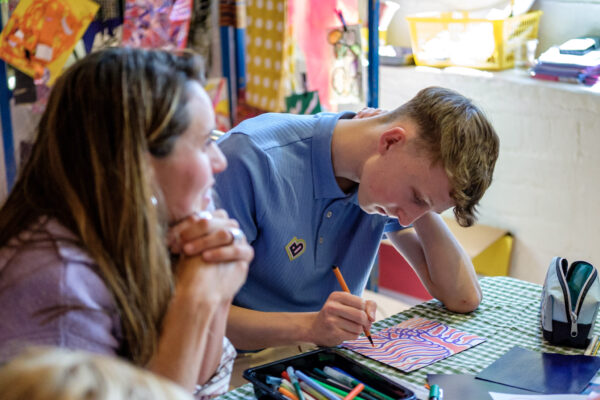 Young man creating a colourful drawing at a workshop