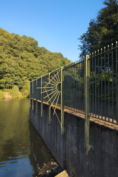 railings next to a path seperating a path and body of water