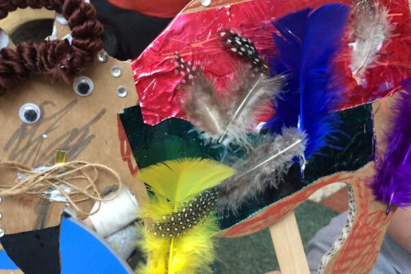 A collage of various materials including cardboard, feathers and googly eyes