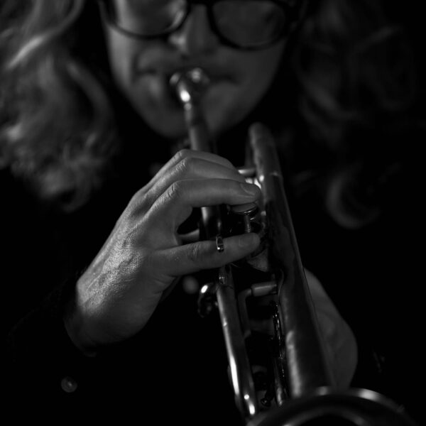 Black and white: close up of a man playing trumpet