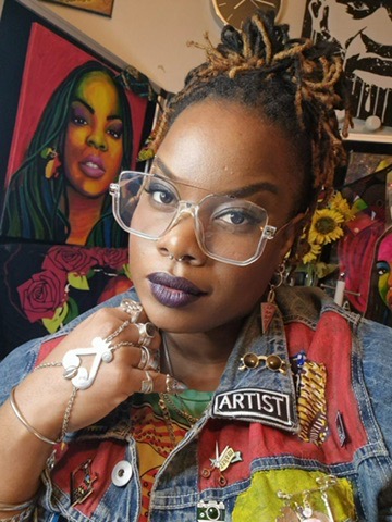 A black woman with wide frame glasses and dyed braids poses for the camera