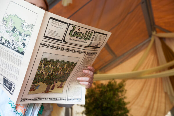 A person reads the newspaper inside the tent.