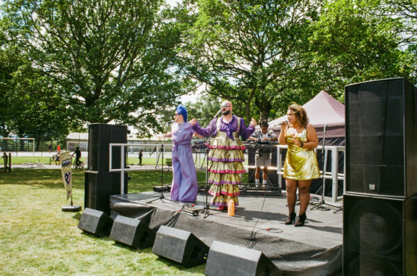 A film photo of three people performing on the stage.