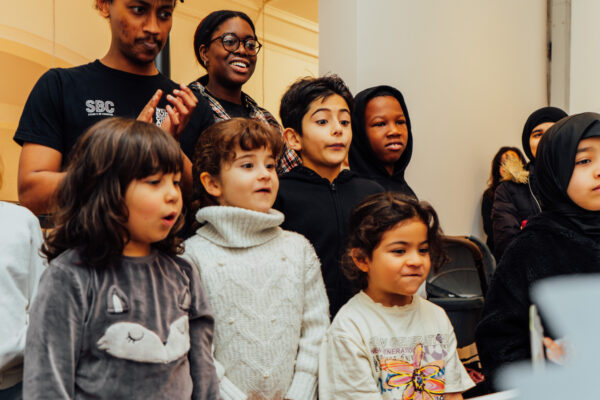 A group of children look at something to the right.
