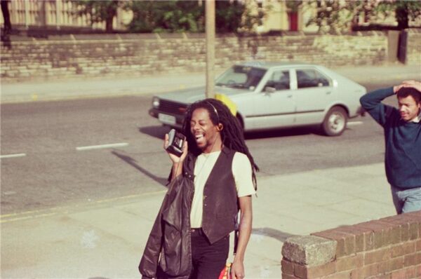 A man with long dreads poses with his walkman on the pavement