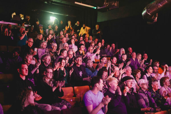 A crowd of people applauding in the Loading Bay theatre.