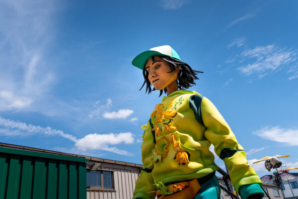 Puppet, Zee, wearing a yellow tracksuit top and blue hat.