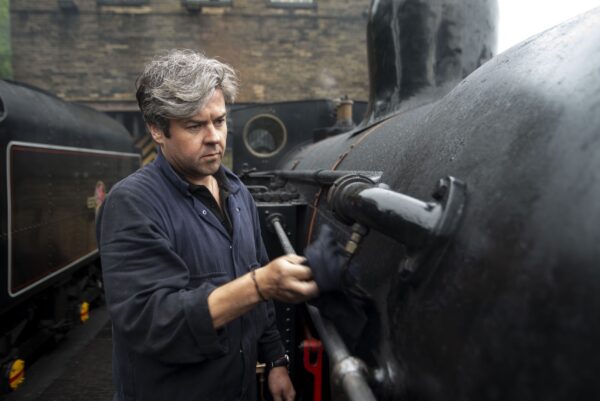 Man cleaning a steam train