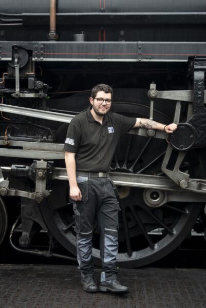 Young man leaning on a steam train