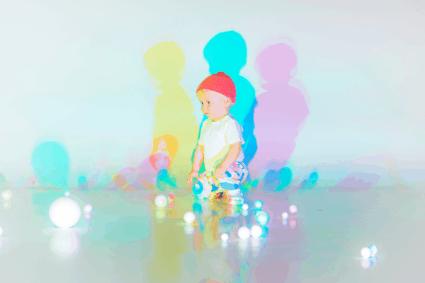 young boy with lots of balls/ spheres around him on the floor
