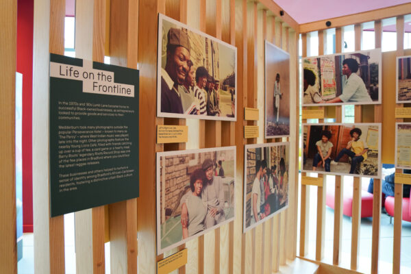 Brightly coloured interpretation is mounted on wooden boards - showing pictures from the exhibition.