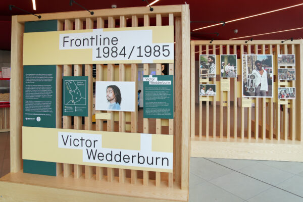 Brightly coloured interpretation is mounted on wooden boards - showing pictures from the exhibition.