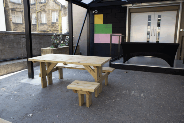 A bench with wheelchair access outside of loading bay