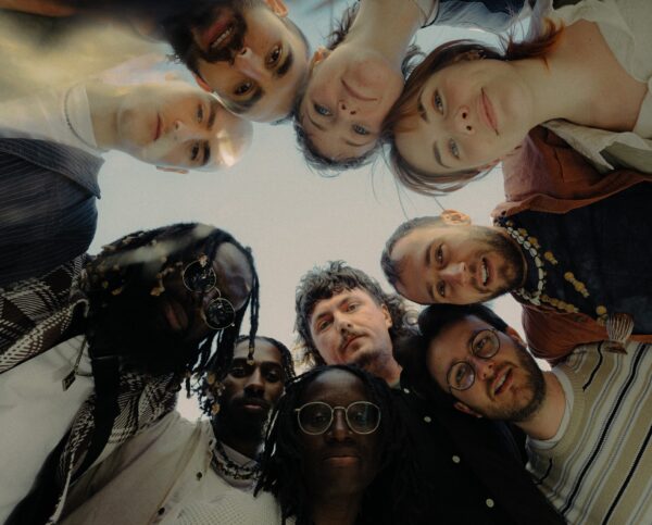 Group of people stood in a circle, looking down at the camera.