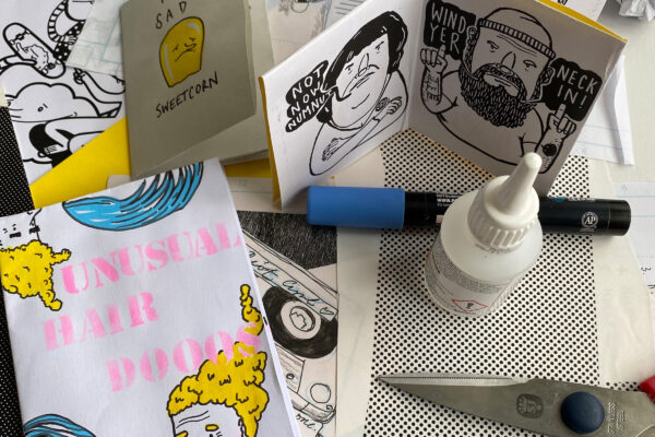 Cartoon / comical drawings, with pens glue and scissors on the table