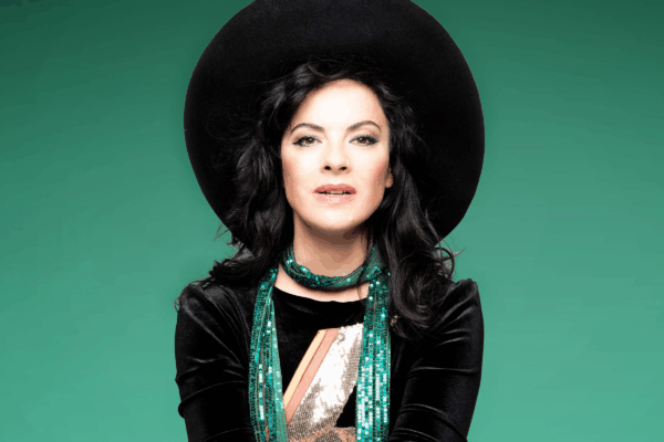Camille Osullican headshot, lady posing wiht a large black hat on