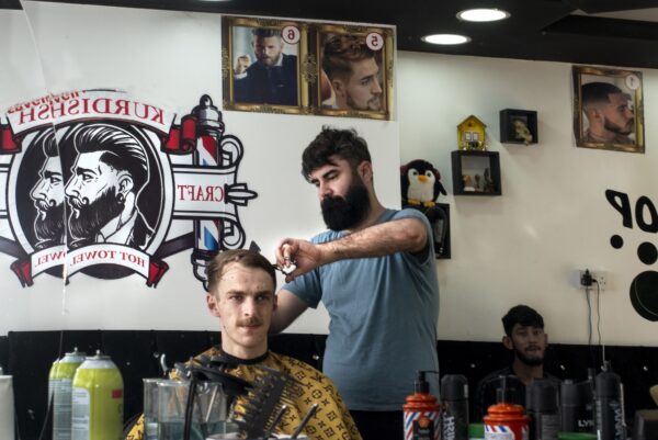 a man getting his ahir cut in a barbers shop
