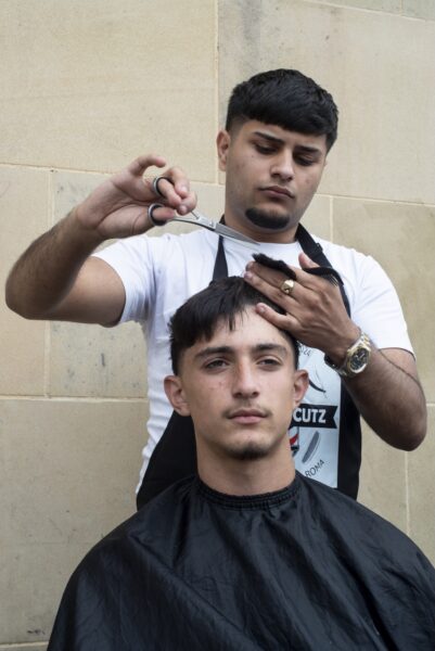 a man getting his hair cut outside