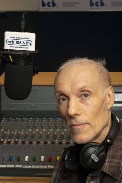 Radio presenter posing infront of his microphone