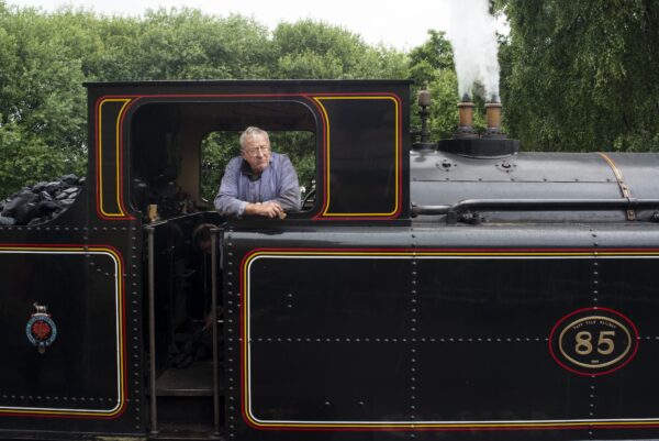 Man leaning out of a steam train window