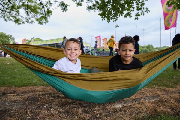 Two boys smiling in a hammock.