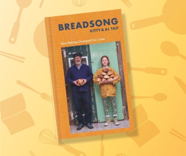 A man and a young woman holidng lots of loafs of bread in their arms, on the front cover of a book titled, Breadsong